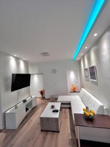 a living room with a white couch and a flat screen tv at Hugolina LUX in Belgrade +6 photos
