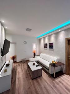 a living room with a white couch and a tv at Hugolina LUX in Belgrade