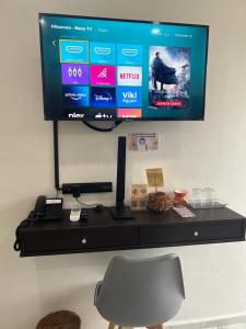 una scrivania con TV su un muro e sedia di Hotel Ko'ox Wenne a Tulum
