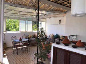 d'une terrasse avec une table, des chaises et une table, ainsi que de quelques fenêtres. dans l'établissement Dar Lalla Wafae, à Fès