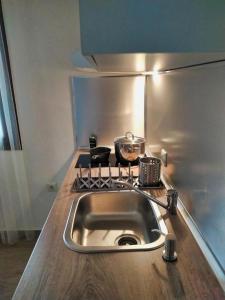 a kitchen counter with a sink and a stove at Guesthouse Kastelia in Kalabaka