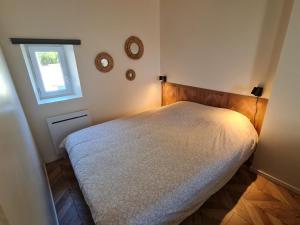 ein Schlafzimmer mit einem weißen Bett und einem Fenster in der Unterkunft Studio 2/4 personnes centre Bayeux in Bayeux