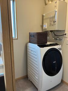 a washing machine with a basket on top of it at Furano Yayoi-house　 in Furano