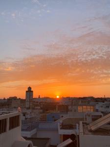 a view of the sunset from the roof of a city at RIAD MAROSKO in Essaouira