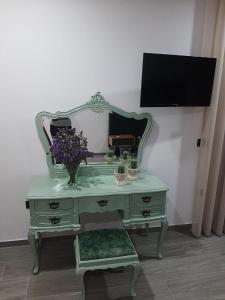 einen grünen Schreibtisch mit einem Spiegel und Blumen darauf in der Unterkunft CRASTO PAYVA DOURO NATURE in Castelo de Paiva