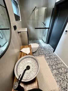 a bathroom with a sink and a toilet and a mirror at Okno Na Wodę- całoroczne domy z linią brzegową jeziora i sauną in Rybno