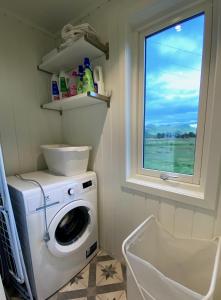 baño con lavadora y ventana en Mountain Panorama en Bøstad