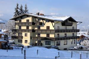 a large building with snow on the ground at Hotel Garni Ingeborg in Westendorf