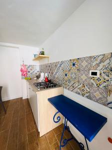 a small kitchen with a stove and a blue table at Oltremare Apartments in Santa Flavia