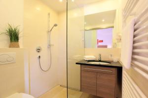 a bathroom with a shower and a sink at Hotel Garni Ingeborg in Westendorf