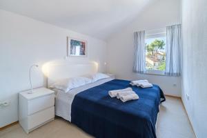 a white bedroom with two towels on a bed at ameli in Milna