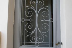 a door with a wrought iron gate on it at Studio Le Nid du Saleys in Salies-de-Béarn
