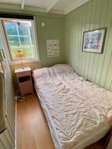 Bett in einem Zimmer mit Fenster in der Unterkunft Mountain Panorama in Bøstad