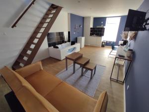 sala de estar con sofá y escalera en NG SuiteHome - Lille I Tourcoing Blanc Seau - Duplex - Balnéo - Netflix - Wifi - Kitchenette, en Tourcoing