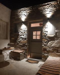 Pokój z drzwiami i kamienną ścianą w obiekcie Psathi w mieście Kitnos