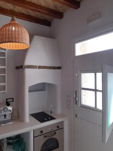 eine Küche mit Herd und Fenster in der Unterkunft Psathi in Kythnos