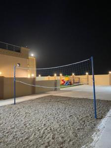 a volleyball net on a beach at night at Almouj Chalet in Salalah