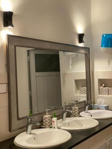 a bathroom with three sinks and a large mirror at Almouj Chalet in Salalah