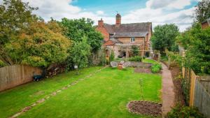 uma imagem de um quintal com uma casa em Morningside Cottage em Tenbury