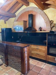 a kitchen with a counter with a sink and a stove at Casa Obis in Muñeca