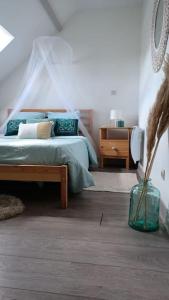a bedroom with a bed and a vase on the floor at Agréable duplex Gare in Le Mans