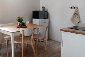 a kitchen with a table with chairs and a microwave at Agréable duplex Gare in Le Mans