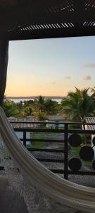 uma rede de descanso numa varanda com vista para o oceano em Hotel Tibau Lagoa em Pipa
