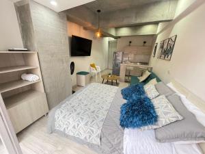 a bedroom with a bed with a blue pillow on it at S306- Apartaestudio Loft en el Norte de Armenia in Armenia