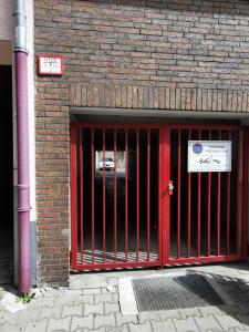 eine rote Tür mit Balken an einem Backsteingebäude in der Unterkunft Apartment Düsseldorf-Süd in Düsseldorf