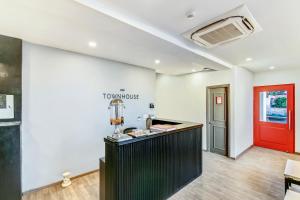 a room with a counter and a red door at Super Townhouse 070 Knowledge Park ||| Near Sharda University in Greater Noida
