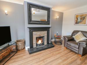 a living room with a fireplace and a couch at Rose Cottage in Barnard Castle