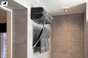 a bathroom with a bunch of towels hanging on a wall at Blackbird Accommodation and Luxury Apartments room 12 in Blackpool +17 photos