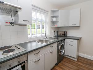 a kitchen with a sink and a washing machine at Rose Cottage in Barnard Castle