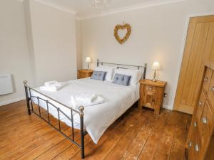 a bedroom with a bed with white sheets and blue pillows at Rose Cottage in Barnard Castle