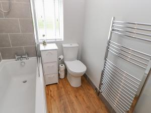 a white bathroom with a toilet and a window at Rose Cottage in Barnard Castle +31 photos