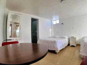 1 dormitorio con cama, mesa y espejo en Hospedaje Bellido, en Ayacucho