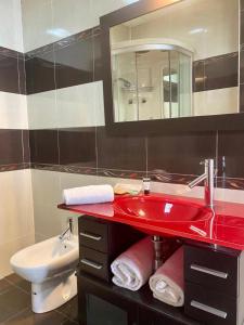 een badkamer met een rode wastafel en een toilet bij El Rincón de Rita - Benicassim in Benicàssim