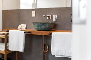 a bathroom with a counter with a sink and towels at The White Swan Hotel in Greytown