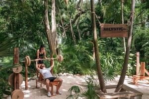 a man and a woman playing in a tree swing at The Reef Playacar Resort & Spa-Optional All Inclusive in Playa del Carmen