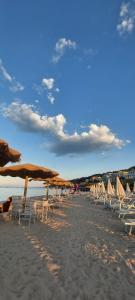 un groupe de chaises et de parasols sur une plage dans l'établissement La Magnolia a 500mt dal mare, à Marina di San Vito