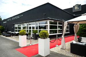 a black building with a red carpet in front of it at Hotel Europejski in Nysa