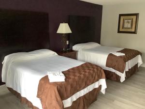 una habitación de hotel con 2 camas y una lámpara en Heritage Park Inn, en Kissimmee