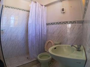 a bathroom with a toilet and a sink at Hospedaje Bellido in Ayacucho