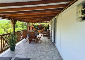 patio z drewnianą pergolą na domu w obiekcie A l'ombre du goyavier w mieście Le François