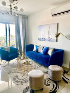 a living room with a blue couch and two chairs at Super Luxurious L6 Sky Blue Apartment in Santo Domingo
