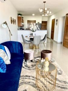 ein Wohnzimmer mit einem blauen Sofa und einem Tisch in der Unterkunft Super Luxurious L6 Sky Blue Apartment in Santo Domingo