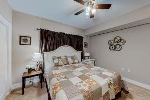 a bedroom with a bed and a ceiling fan at Paradise Shores 105 in Mexico Beach