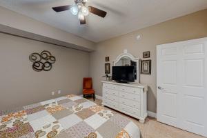 a bedroom with a bed and a flat screen tv at Paradise Shores 105 in Mexico Beach