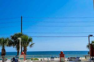 a beach with chairs and palm trees and the ocean at Paradise Shores 105 in Mexico Beach