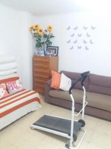 a living room with a treadmill and a couch at Habitaciones cerca del mar in Reus